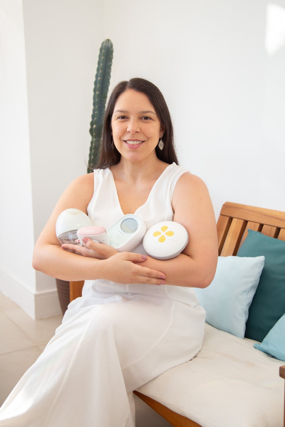 Dra. Marcela Arruda, médica e consultora de amamentação, sentada com bombas de leite no colo